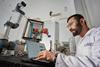 A researcher sat with a laptop in a laboratory setting