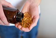 A,Person,Pours,Golden,Soft,Gel,Capsules,From,A,Brown