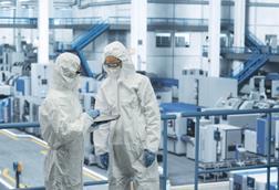 Two,Female,Technicians,In,Protective,Coveralls,Having,A,Conversation,And