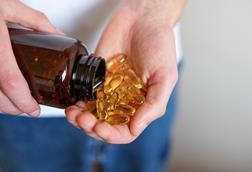 A,Person,Pours,Golden,Soft,Gel,Capsules,From,A,Brown