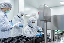 team-workers-protective-gear-inspecting-pharmaceutical