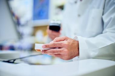 pharmacist-holding-medication-box-scanning-barcode