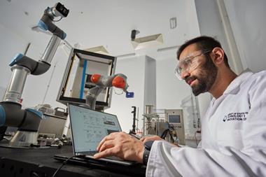 A researcher sat with a laptop in a laboratory setting