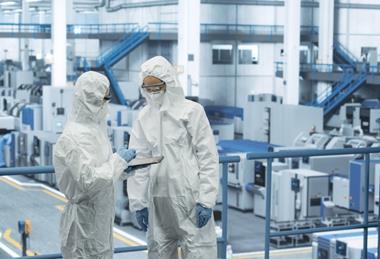 Two,Female,Technicians,In,Protective,Coveralls,Having,A,Conversation,And