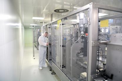 medical products manufacturing in a modern factory - worker operates modern industrial plant