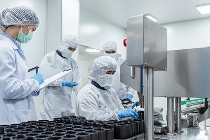 team-workers-protective-gear-inspecting-pharmaceutical