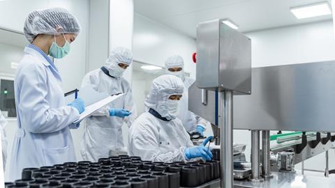 team-workers-protective-gear-inspecting-pharmaceutical