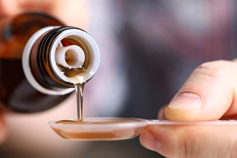 person holding vial syrup